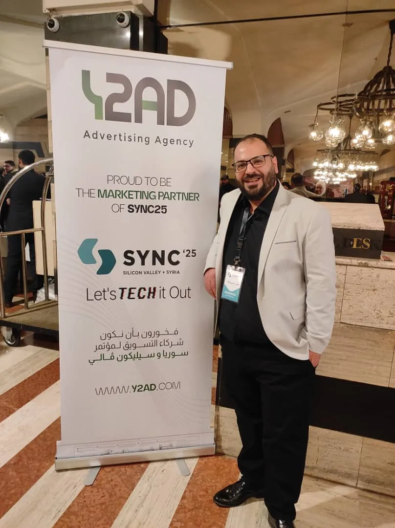 Jabr beside the Y2AD marketing-partner roll-up at SYNC '25